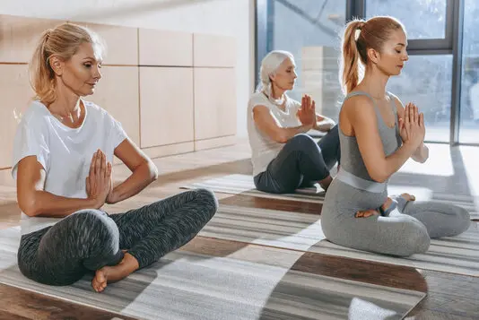 Person sitzt auf einem Stuhl und macht ruhige Atem- und Entspannungsübungen