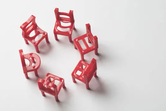 Kleine Gruppe von Menschen sitzt im Stuhlkreis und unterhält sich