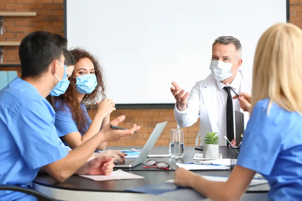 Ärztin spricht vor einer kleinen Gruppe von Zuhörenden
